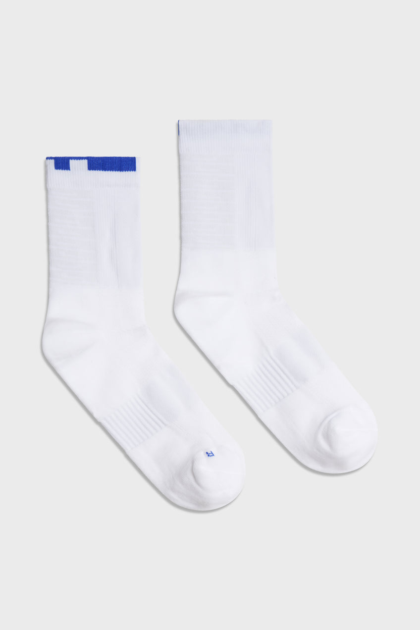 Pair of white TIOTIO Performance Socks on a light grey background