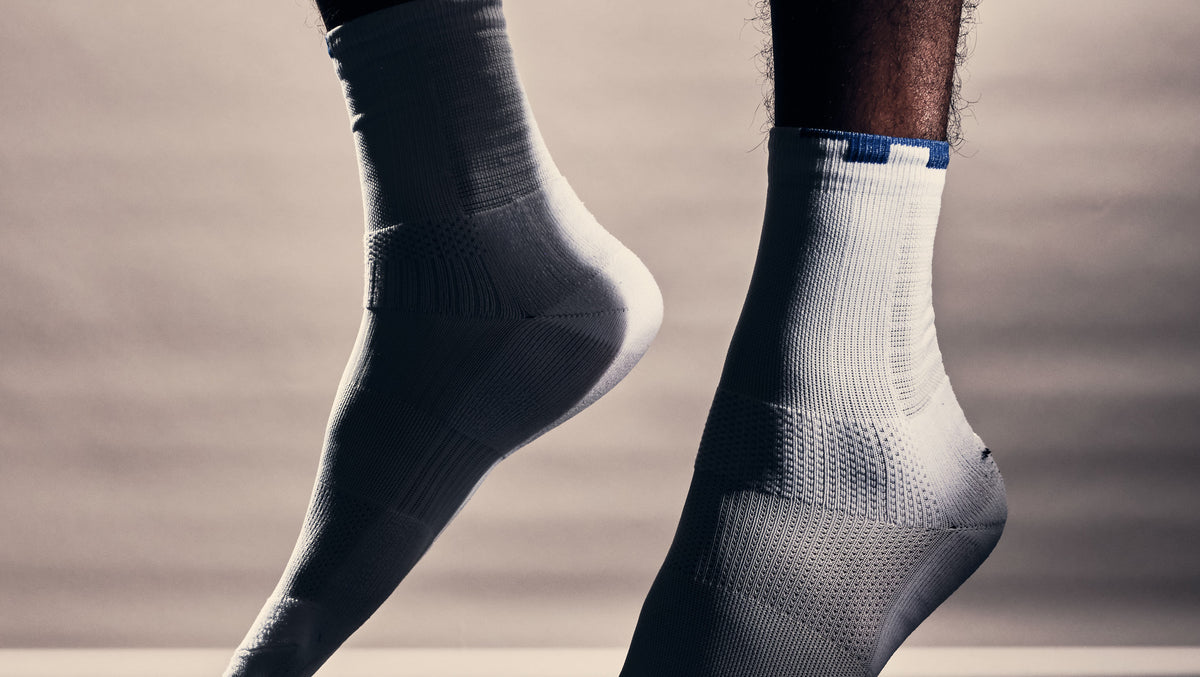 Close-up of the white TIOTIO On-Court Socks mid-stride