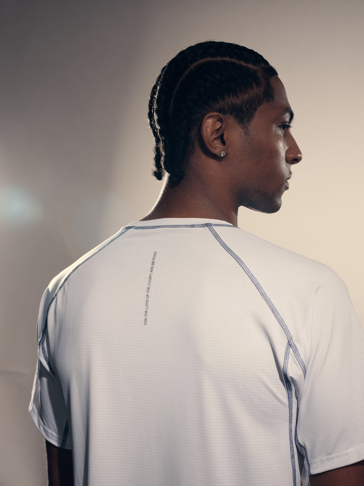 Back shoulder detail of the white TIOTIO Performance Tee with the "For the love of the court and beyond" print